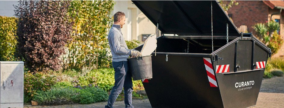 Person wirft Eimer in Container